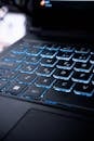 A detailed image of a backlit laptop keyboard with blue lighting creating a modern tech vibe.